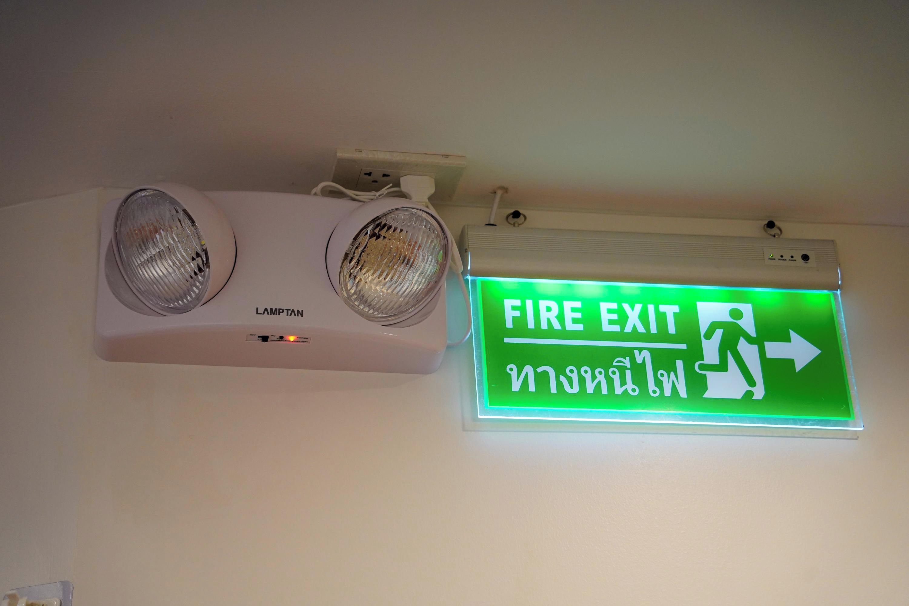 A fire exit sign with an illuminated green background and an arrow pointing right, indicating the direction to the fire exit.