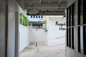 Un pasillo que lleva a un edificio con un letrero que dice 'KopiBara House'.