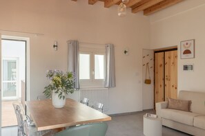 Un salon moderne avec une table à manger en bois, un canapé et une fenêtre avec des rideaux.