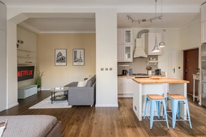 Une cuisine moderne dotée d’un îlot central, de tabourets de bar et d’un coin repas.
