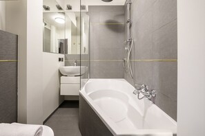 A modern bathroom with a large bathtub, a separate sink, and a shower area. - Lumina 2room Apt w/ Parking near center (Warszawa)