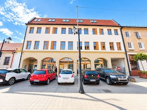 A multi-story building with a row of parked cars in front. - Urbans Hotel (Bucharest)