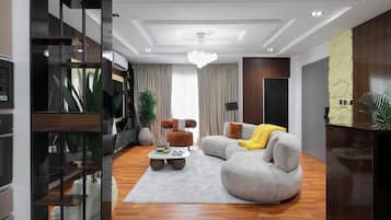 Una sala de estar moderna con un sofá seccional gris, una mesa de centro y una planta grande.