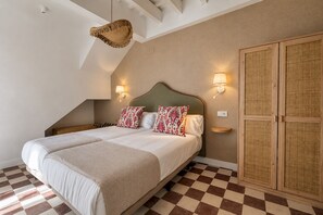 A double bed with patterned pillows, two wall-mounted lamps, a woven basket, and a checkered floor. - Genteel Home Patio del Arenal Terrace 301 (Seville)