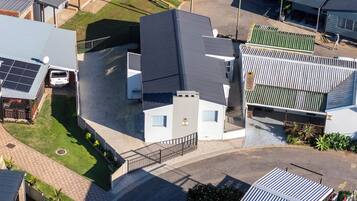 A residential area with multiple houses, a paved driveway, and a solar panel installation.