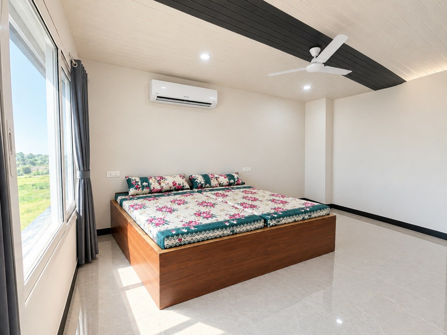 Een slaapkamer met een bed, een airconditioning, een plafondventilator en uitzicht op het omliggende landschap.