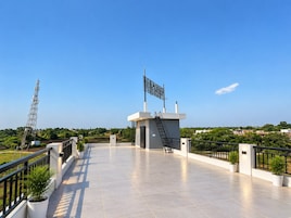 Una terraza en la azotea con una bandera, una estructura metálica y vistas del entorno.