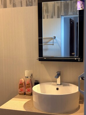 A bathroom with a round sink, a mirror above it, and two bottles of soap on the counter. - 3-bedroom house with AC in lovely Ahangama (Ahangama)