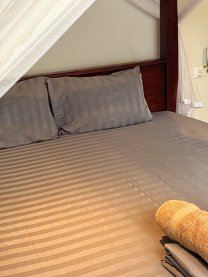 A bed with a canopy, pillows, and a rolled-up towel. - 3-bedroom house with AC in lovely Ahangama (Ahangama)