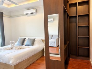 Una habitación de hotel con cama, armario y espejo.