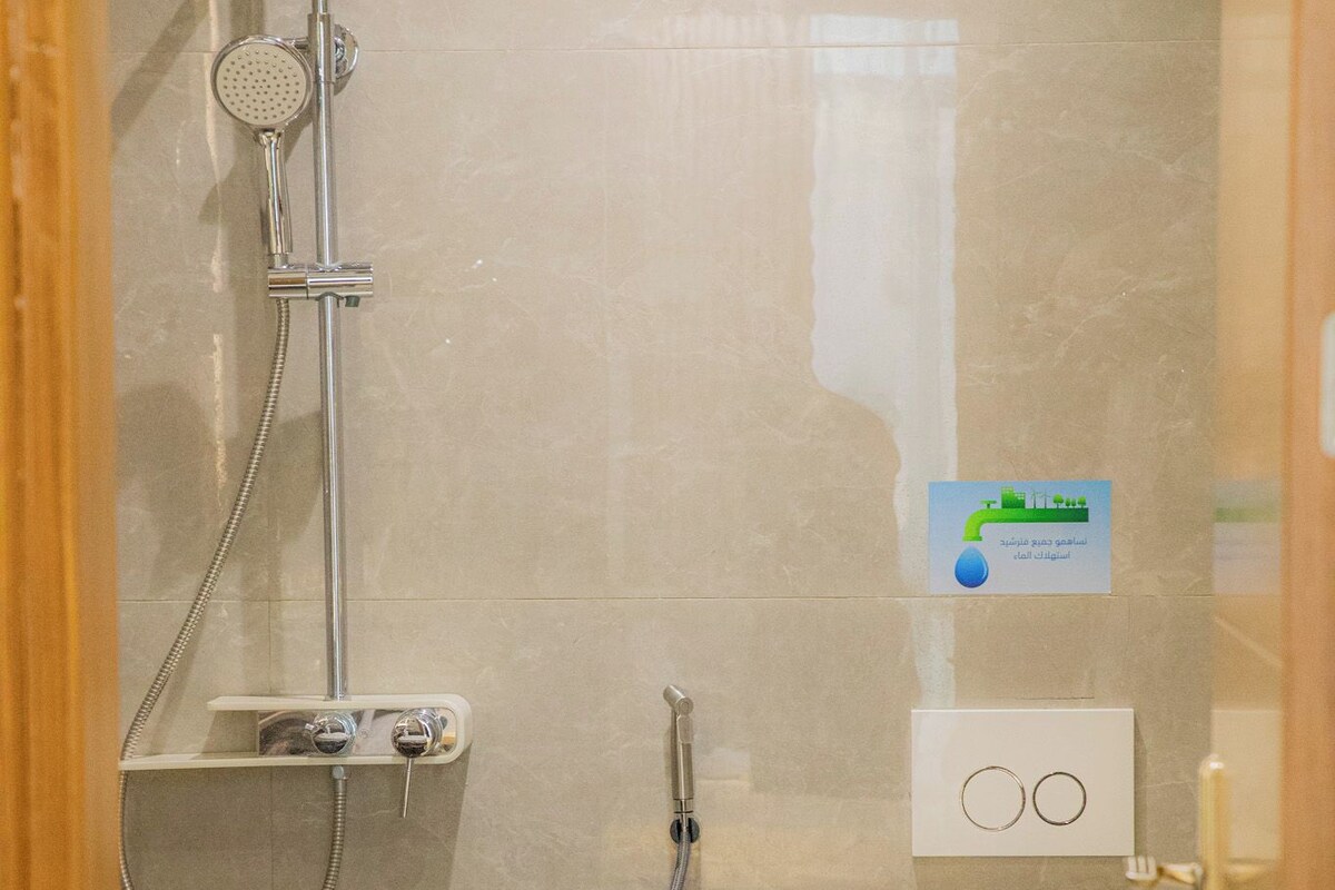 A bathroom with a shower, toilet, and sink.