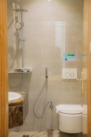 A bathroom with a shower, toilet, and sink. - Lavi Park (Makkah)