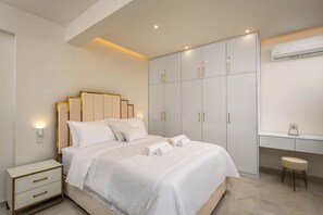 A modern bedroom with a bed, nightstands, a wardrobe, and a desk with a chair. - Annamaria's Apartment (Rodos)