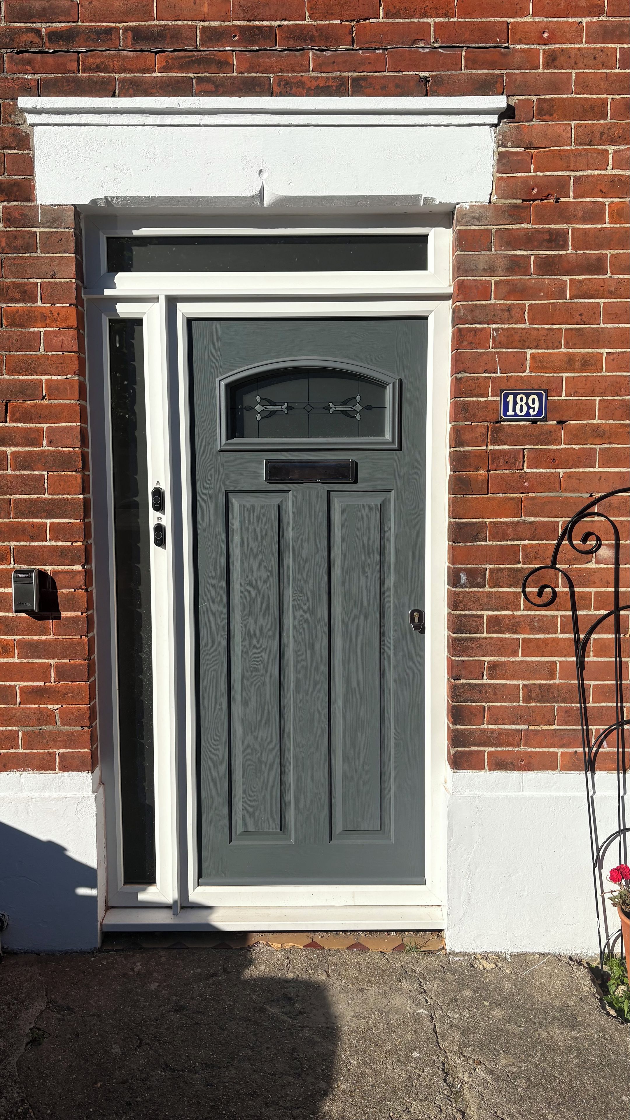 A grey door with a mail slot and a number plate indicating '189'.