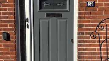 A grey door with a mail slot and a number plate indicating '189'.