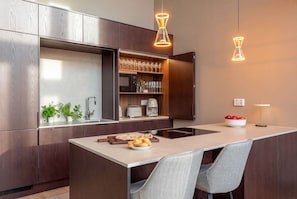 A modern kitchen with a central island, pendant lighting, and built-in appliances. - Stay North: Joiku - Kiruma (Kolari)
