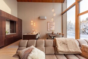 A modern living room with a sectional sofa, a dining table, and pendant lighting. - Stay North: Joiku - Kiruma (Kolari)