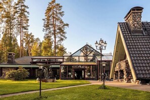 Eine Lodge mit einem Steinofen, einem Glastür und einem gepflegten Rasen.