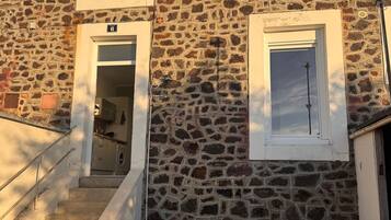 Un bâtiment en pierre avec un escalier menant à une porte portant le numéro 6.