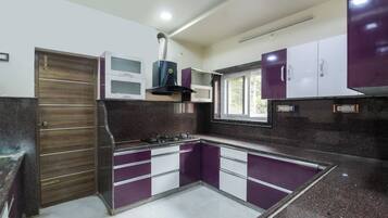 A kitchen with a built-in stove, cabinets, and a window.
