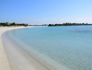 A clear view of a beach with a sandy shore and calm water. - Riva Dorata Torre Lapillo Balcone Privato & Parcheggio (Porto Cesareo)