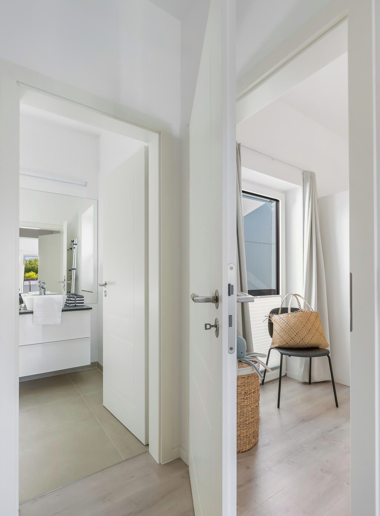 A modern bathroom with a large mirror, a sink, and a shower area.