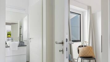 A modern bathroom with a large mirror, a sink, and a shower area.