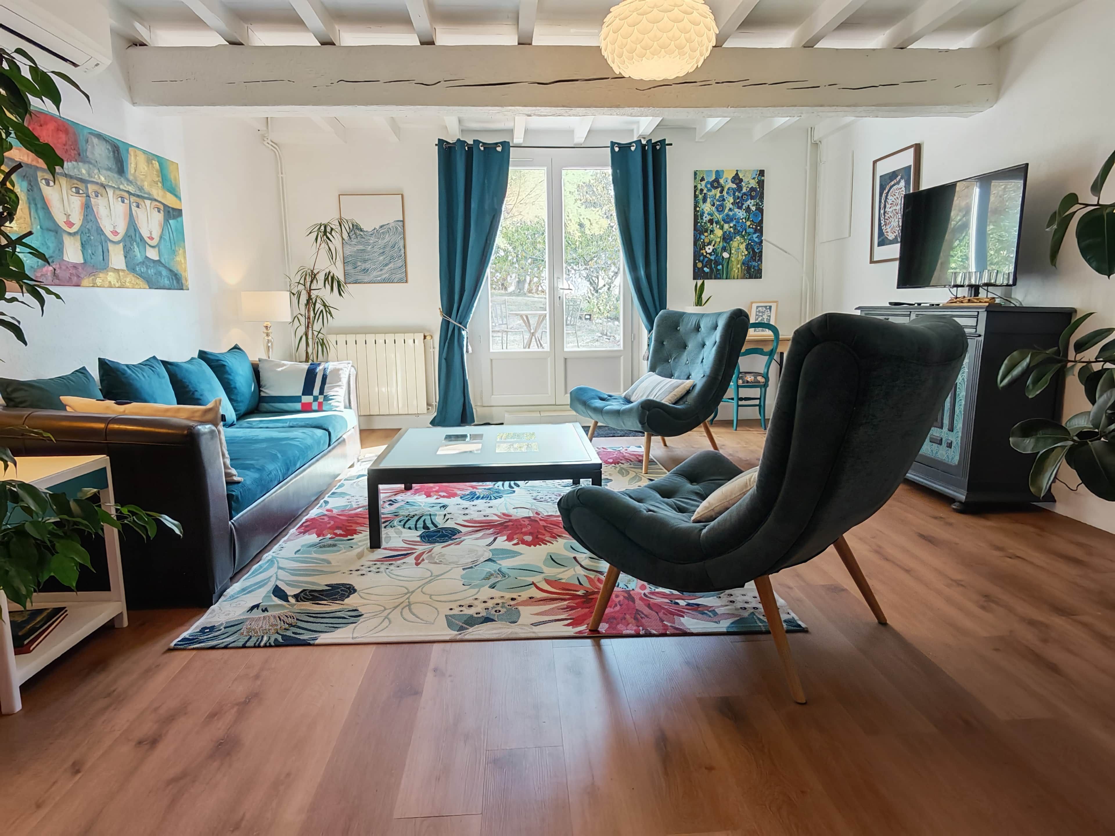 Un salon comprenant un canapé, des fauteuils, une table basse et un téléviseur.