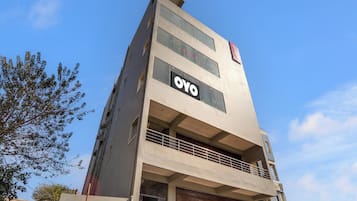 A multi-story building with a prominent 'OYO' sign on the facade, a visible balcony on the upper floor, and a storefront with 'CHi REDDY' signage.