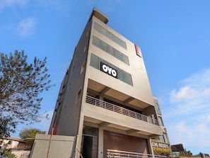 A multi-story building with a prominent 'OYO' sign on the facade, a visible balcony on the upper floor, and a storefront with 'CHi REDDY' signage.