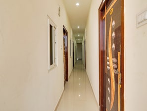 A corridor with doors on both sides, a tiled floor, and a ceiling with recessed lighting. - Super Collection O RBS Classic Stay  (Hyderabad)