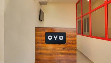 Una mesa de recepción con un cartel que dice 'OYO' sobre un fondo de madera.