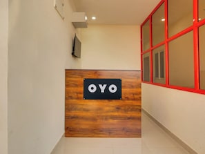 A reception desk with a sign that reads 'OYO' against a wooden backdrop. - Super Collection O RBS Classic Stay  (Hyderabad)
