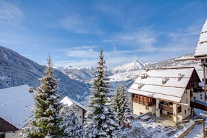 Un pueblo cubierto de nieve en la montaña, con casas tradicionales de madera y una vista despejada de los picos circundantes.