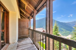 Un balcón de madera con vista a un paisaje montañoso.