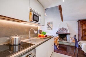 A modern kitchen with a built-in microwave, stainless steel sink, and a stove. - Home Suite Grange (Sauze di Cesana)