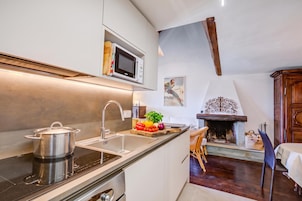 Una cocina moderna con microondas integrado, pileta de acero inoxidable y estufa.