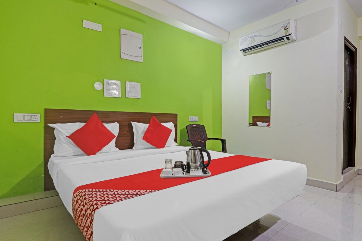 Una habitación de hotel con cama, cafetera y aire acondicionado de pared.