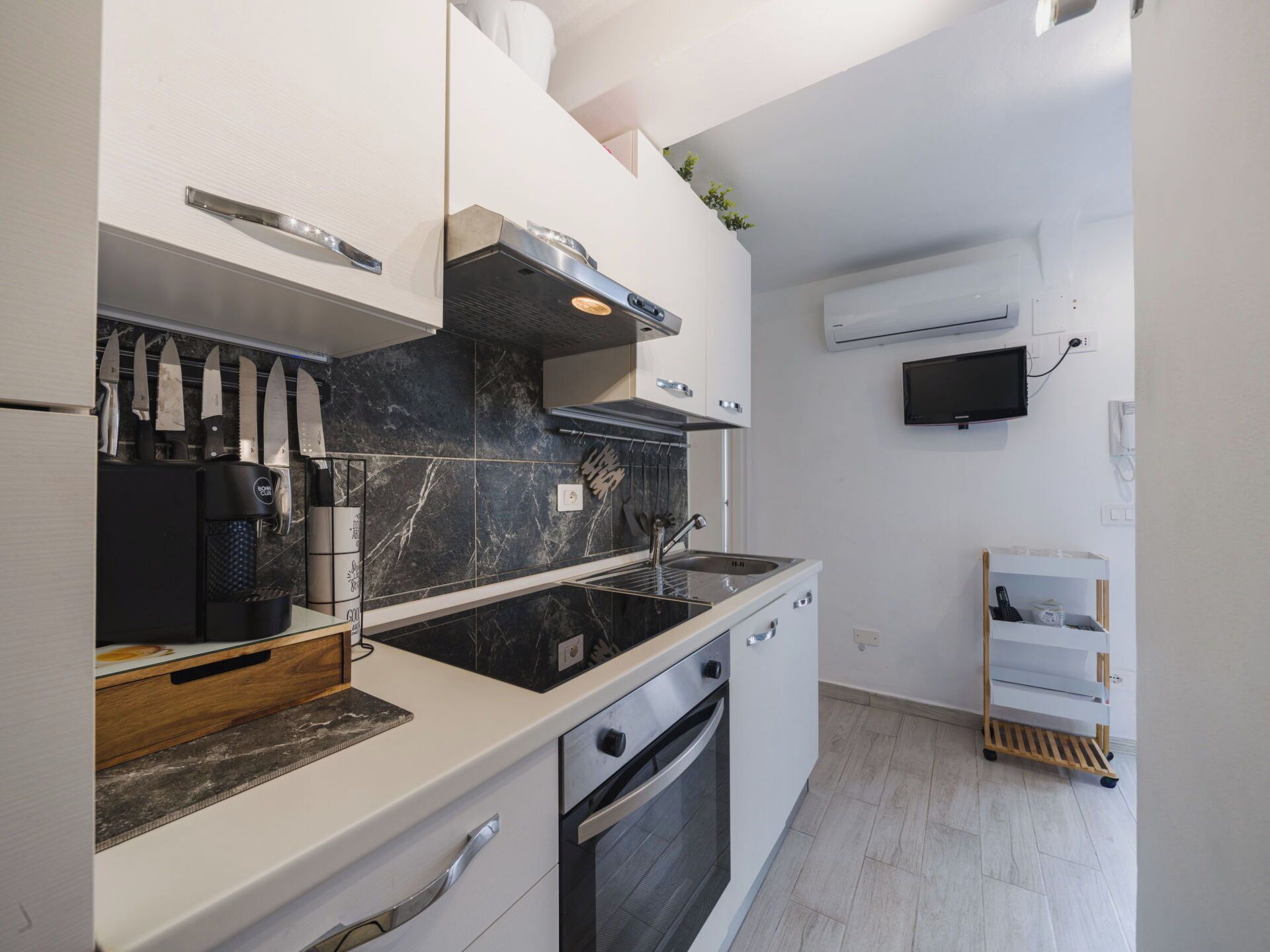 A modern kitchen with a black marble backsplash, stainless steel appliances, and a built-in oven.