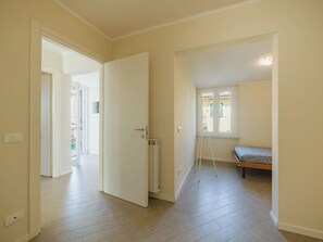 Ein Zimmer mit einem Bett, einem Heizkörper und einem Fenster mit Rollläden.