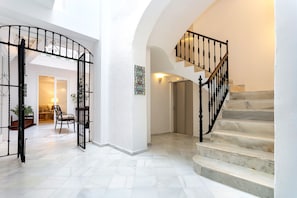 A spacious interior with a marble staircase and a curved black metal railing. - Genteel Home Patio del Arenal (Seville)