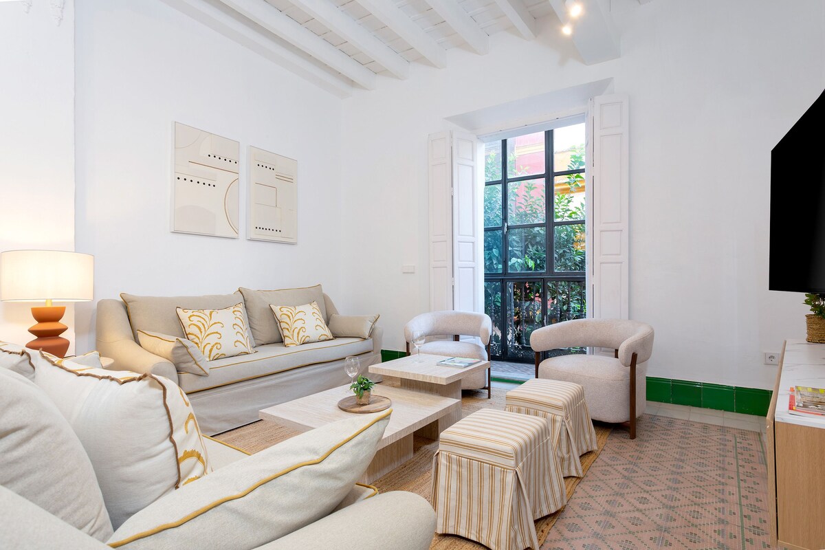 A modern living room with a sofa, armchairs, a coffee table, and a television.