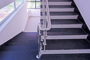 A staircase with black steps and a metal handrail. - Townhouse Karumathampatti SBA's Park Inn (Sulur)