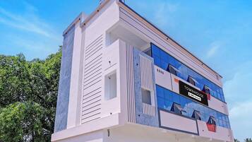 A modern townhouse with a prominent reception area, a sign indicating it is serviced by a specific company, and a clear view of the sky.