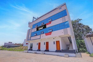 A multi-story building with a sign indicating it is serviced by OYO.