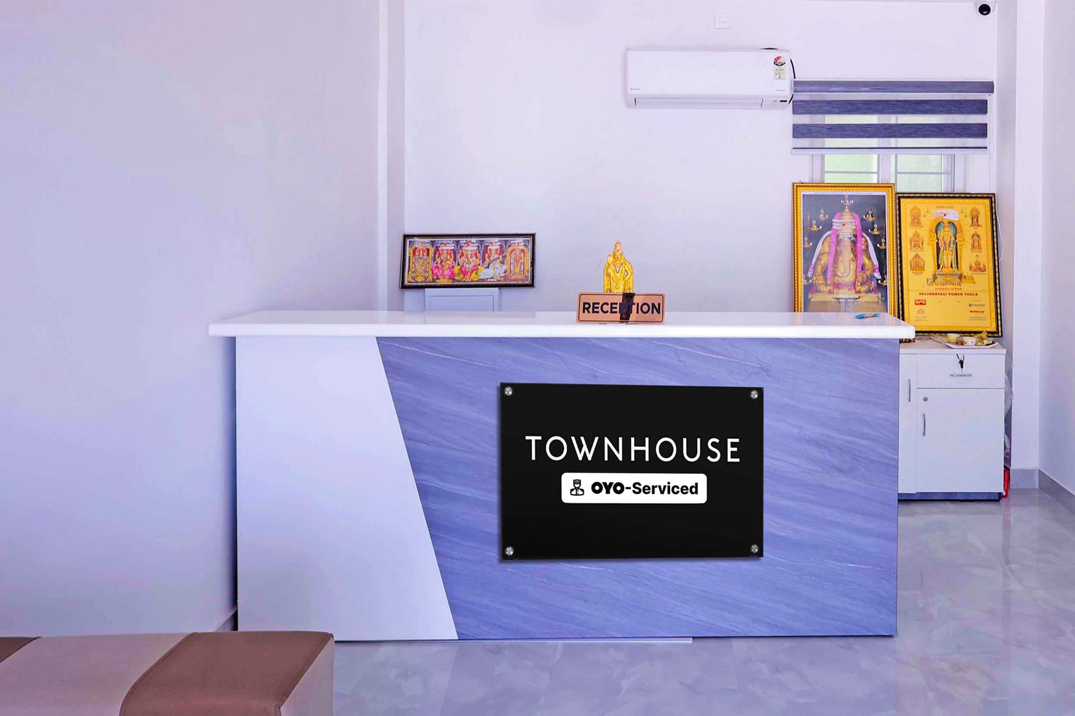 A reception desk with a sign that reads 'TOWNHOUSE OYO-Serviced.'