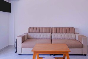Un sofá beige con una mesa de centro de madera.