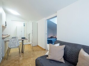Eine moderne Wohnung mit Essbereich, einer Couch und einem Bett.