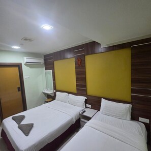 A hotel room with two beds, a wooden headboard, an air conditioning unit, a bedside table, and a nightstand. - Golden Night Hotel Sunway (Petaling Jaya)