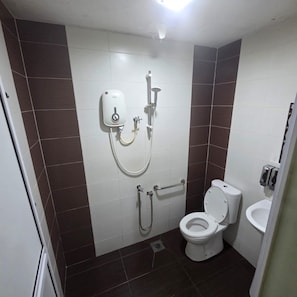 A bathroom with a toilet, a shower unit, and a bidet. - Golden Night Hotel Sunway (Petaling Jaya)